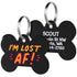 Close-up of black acrylic dog ID tags showing colorful IM LOST AF front text, engraved contact info on back, and metal split rings on white background