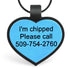 Close-up of two-tone silicone heart ID tag with blue center, black border, engraved I’m chipped and visible phone number