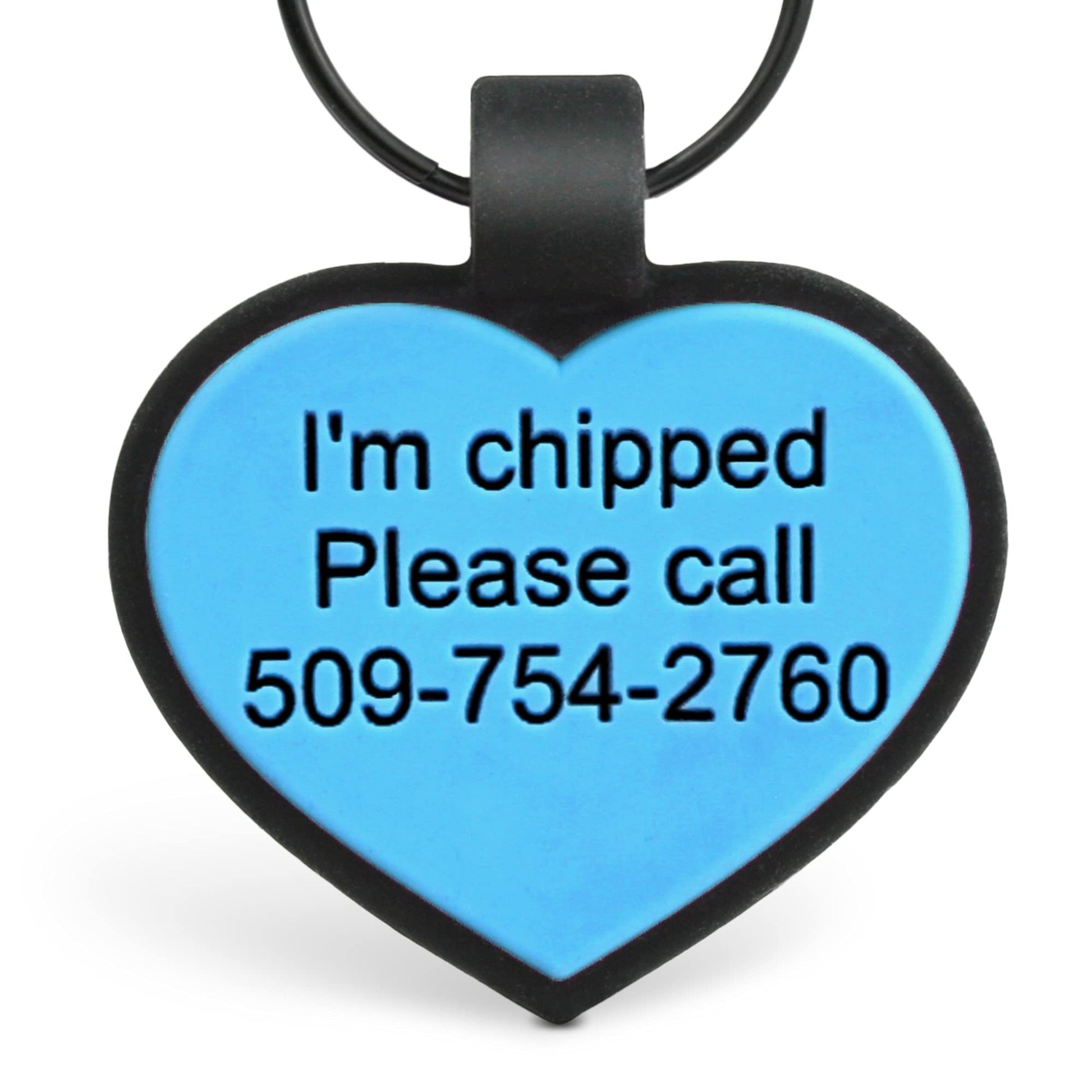 Close-up of two-tone silicone heart ID tag with blue center, black border, engraved I’m chipped and visible phone number