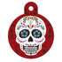 Front view of round Day of the Dead dog ID tag showing colorful sugar-skull design on red with attachment hole on white background