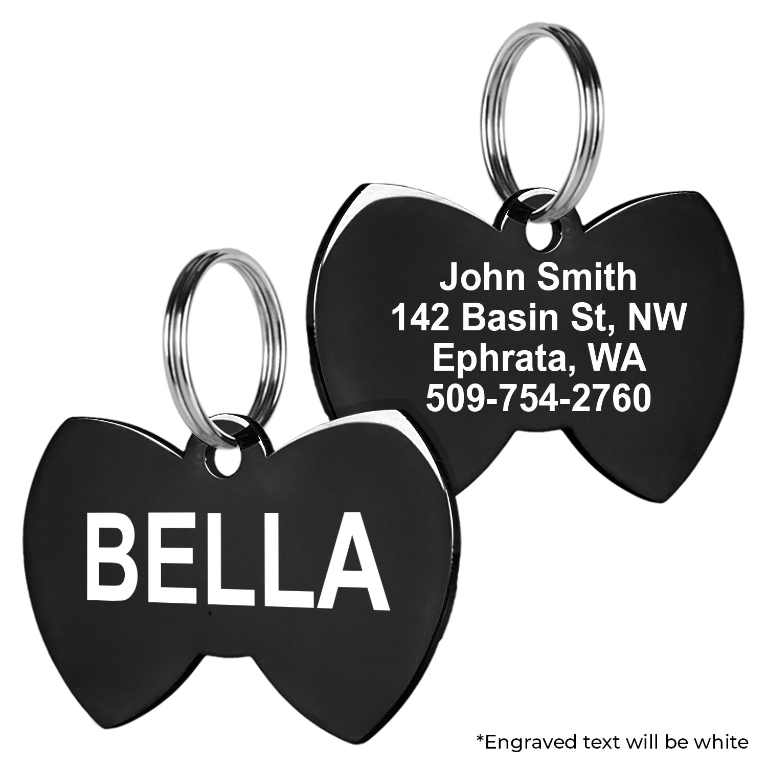 Close-up of black stainless steel bow tie pet tag showing sample engraving on both sides and attached split rings on white background