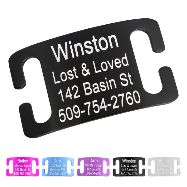 Angled close-up of black Silent Slide-On Dog ID tag with white engraving showing sample name Winston and contact info
