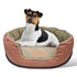 Angled view of orange round dog bed with removable beige cushion, bolstered sides, black base and small dog inside