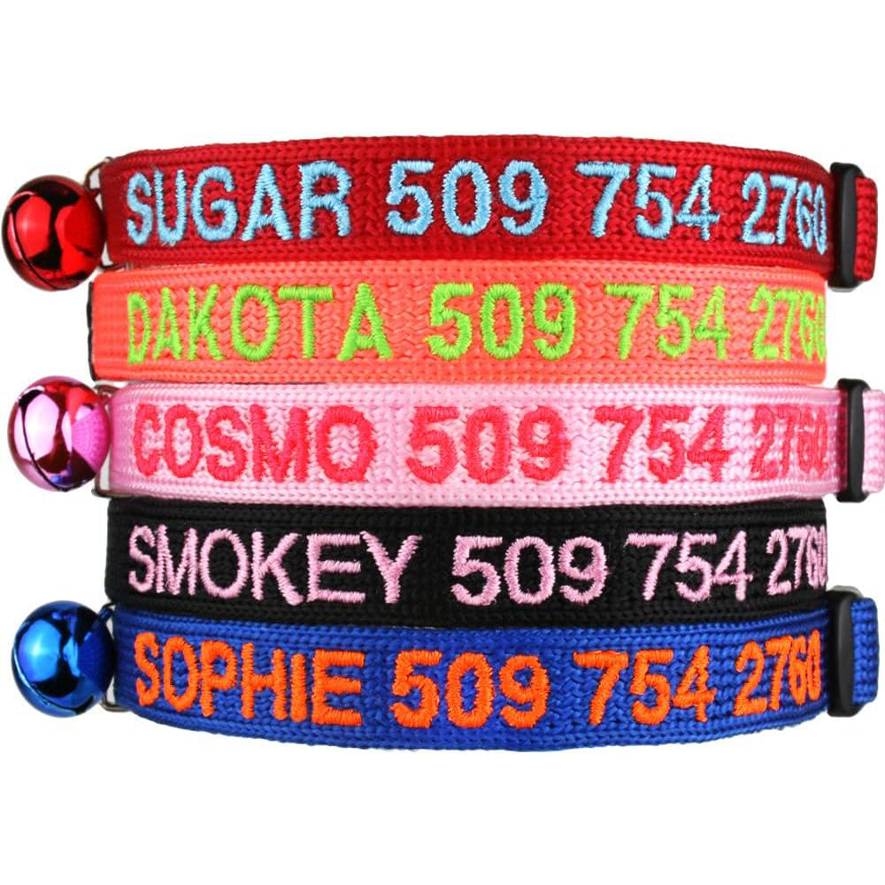 Stacked personalized embroidered cat collars showing names and phone numbers, breakaway buckles and bell