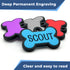 Front view of bone-shaped silent silicone dog tag showcasing engraved name SCOUT on blue tag with stacked colorful tags behind