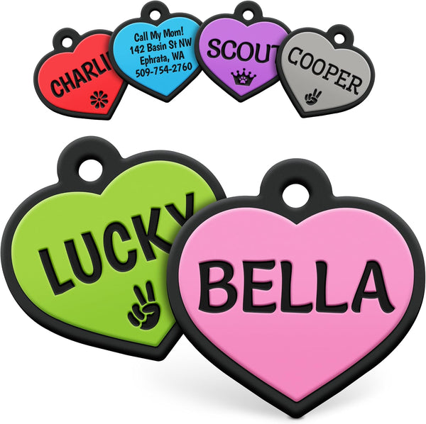 Close-up of heart-shaped silicone pet ID tags showcasing personalized engraved text in multiple colors on a white background