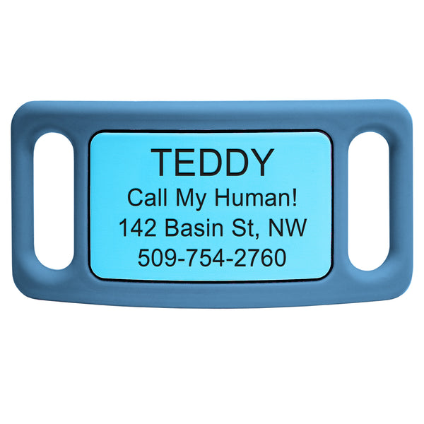 Close-up of blue silicone slide-on pet ID tag showing engraved plate reading TEDDY, Call My Human!, sample address and phone