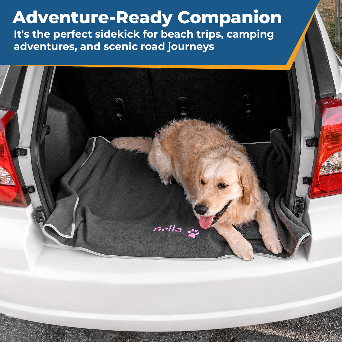 Golden retriever resting on a personalized black fleece dog blanket in a car trunk