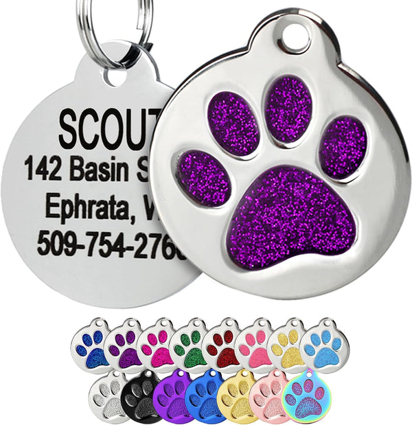 Close-up of a purple glitter paw print pet ID tag showing polished stainless steel and a personalized back