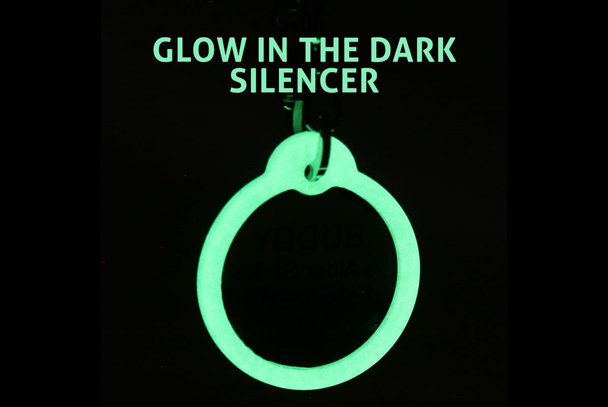 Front view of glow-in-the-dark pet tag silencer showing glowing ring on black background with overlaid text 'GLOW IN THE DARK SILENCER'