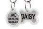 Front close-up of stainless steel pet ID tags showcasing white silicone silencers and engraved names Jake and Daisy on white background